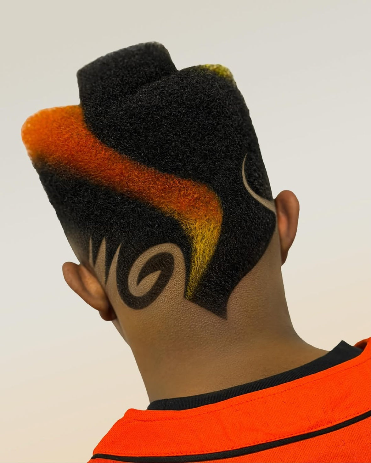Back view of a dimensional black, orange and yellow sculpted hairstyle